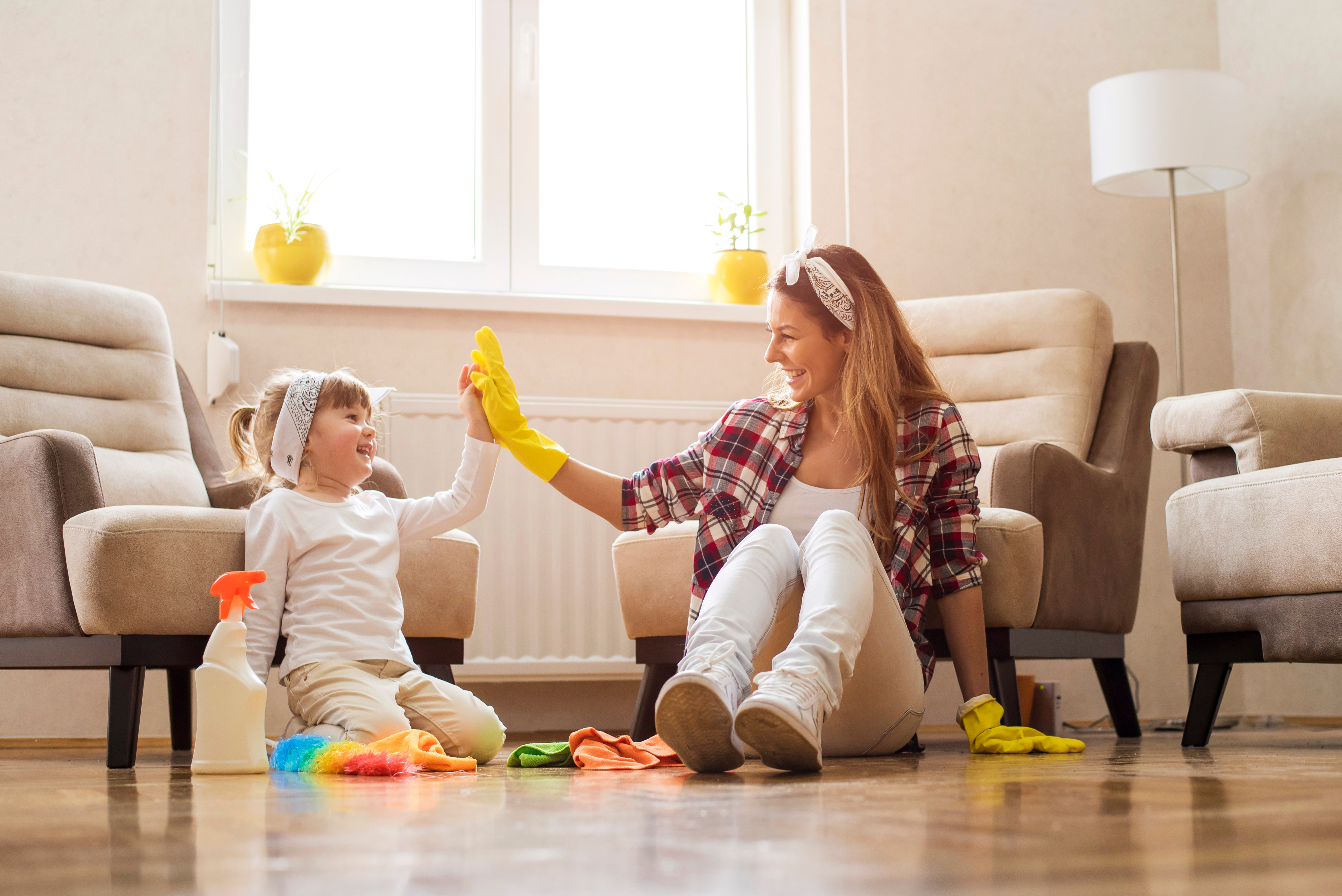 mother and daughter deep cleaning the living room